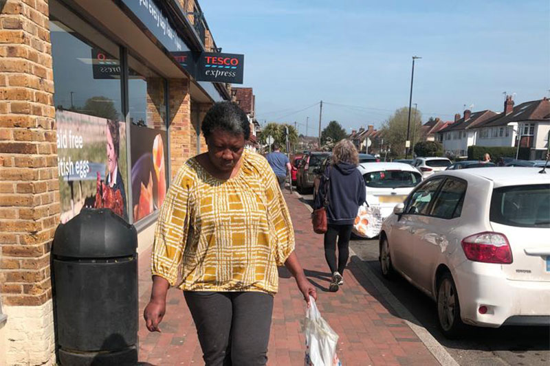 Supported living client carrying shopping bag